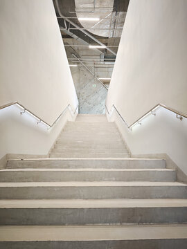 Concrete architecture, a staircase going up, an epic view from below, concrete steps and railings