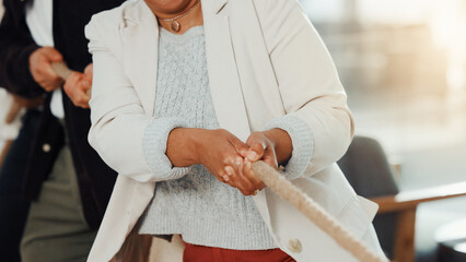 Hands, person and tug of war at office with rope pulling games, challenge and test at company. Business people, team building and group with battle, contest and synergy for competition at workplace