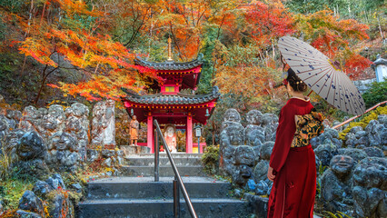 Japanese Woman in Traditional Kimono Dress at Otagi Nenbutsu-ji temple with beautiful foliage in...