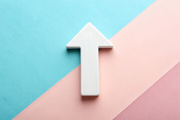 Pink and blue paper features a white arrow pointing up, promoting growth. Great for marketing or presentations.