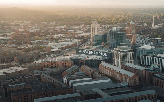 Aerial view of Wolverhampton city center with the Molineux Stadium illuminated by the golden hour sun