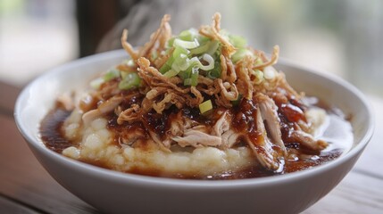 Bowl of savory mashed potatoes topped with shredded chicken and crispy fried onions