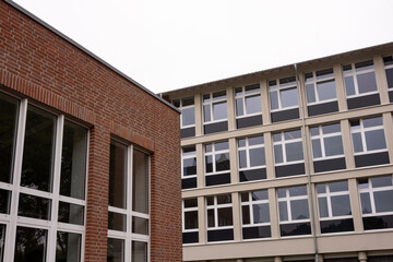 Modern school building with brick and concrete facades and large windows on overcast day