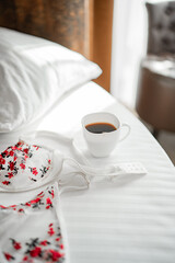 Cozy morning with coffee and floral lingerie on a soft white bed