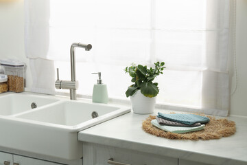 Clean waffle towels on wicker mat near sink
