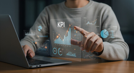 Person working on a laptop, interacting with a virtual "KPI" dashboard displaying various data charts and graphs. Perfect for business analysis and performance.