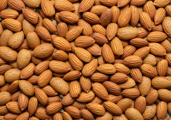 Obraz premium Full frame close-up of many raw almonds, both shelled and unshelled. Perfect for healthy eating and baking concepts.