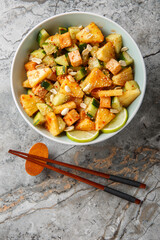 Rojak fruit vegetable salad with tofu cheese close-up in a bowl on the table. Vertical top view from above