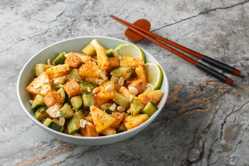 Rojak is a mixed salad combining tropical fruits, vegetables and tofu tossed in a thick dressing closeup in the bowl on the table. Horizontal
