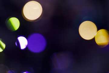 Colorful bokeh lights in various shades of blue, green and yellow create a vibrant, abstract background. © Mariana Rusanovschi