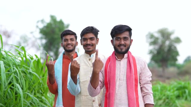three young indian villager showing voting finger	