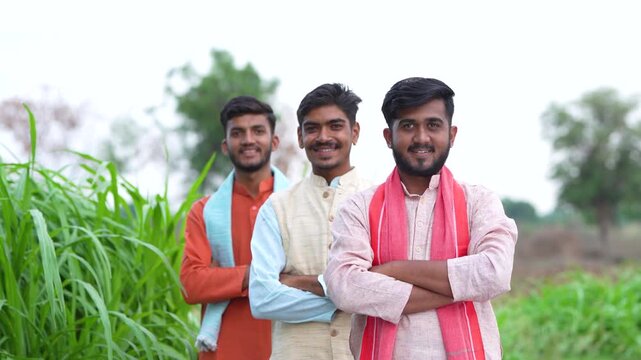 young indian farmer group standing together at green agricultural field	