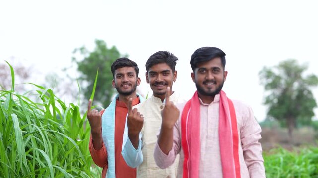 three young indian villager showing voting finger	