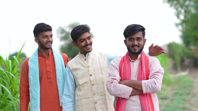 young indian farmer group standing together at green agricultural field	