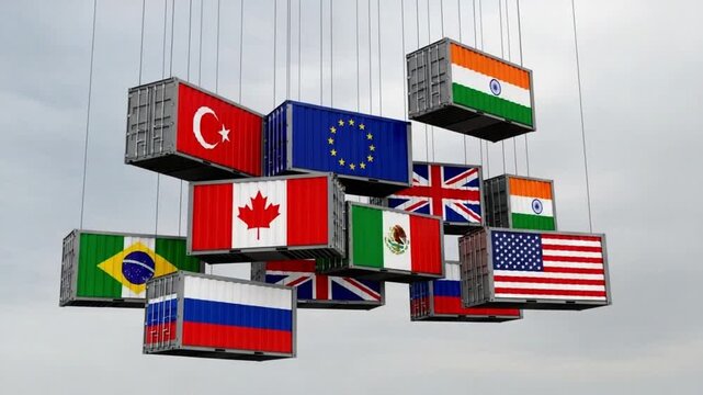 Cargo containers with flags of different countries hanging from above against a cloudy sky backdrop