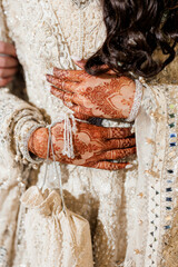 Exquisite Indian bride on her wedding day close-up. Bride's hands in a luxurious beaded wedding...