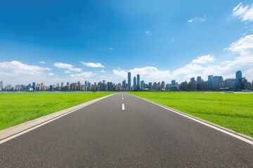 Fototapeta premium Empty asphalt road leading to a city skyline