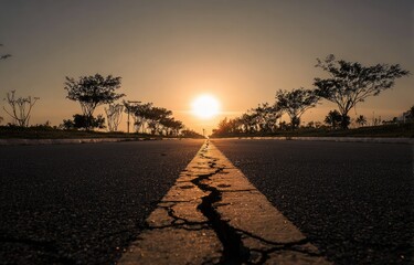Asphalt road leading to a sunset