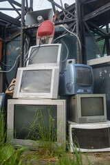 Old CRT TV's piled up in a junkyard