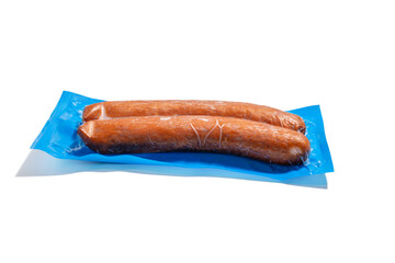 Two sausages in blue vacuum packaging. Two smoked sausages vacuum-packed on blue plastic. The packaging is hermetically sealed and shown isolated on a white background.