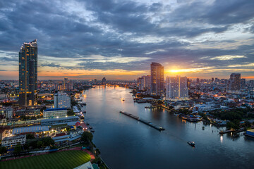 Fototapeta premium Modern buildings in the city with water reflection, firework, light show, river ferry boat at twilight time.