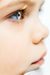 Close-up profile of a child's eye showcasing vibrant blue iris and long eyelashes, highlighting the importance of vision health and eye care in pediatric ophthalmology