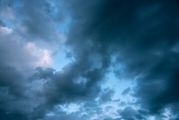 Obraz premium Dramatic dark storm rain clouds black sky background. Dark thunderstorm clouds rainny atmosphere. Meteorology danger windstorm disasters climate. Dark cloudscape storm disaster gloomy gray cloud sky