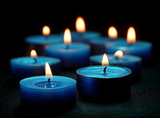 In eerie blue tones, a background of glowing tealight candles illuminates the darkness with soft focus and subtle reflections. The composition creates an atmosphere of peace and contemplation.