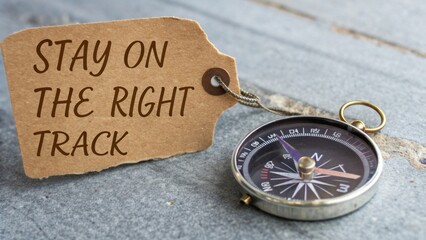 Fototapeta premium Vintage Compass with Stay on the Right Track Tag on Wooden Table