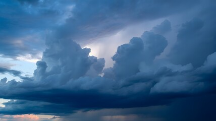 Obraz premium Dramatic dark storm clouds gathering in the sky with a hint of light breaking through the heavy overcast