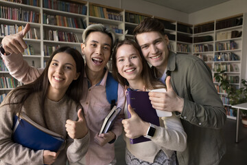 Study team spirit. Casual portrait four joyful multiethnic students peers pose close together hug smile at camera show thumbs up celebrate passing exam successful finishing group project research task