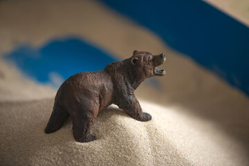 The concept of psychology. Sand
therapy. A bear figurine in a blue
sandbox. Psychology. Therapy. PTSD