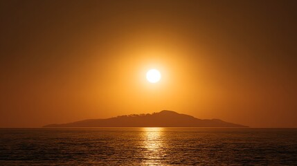 A golden sunset over the sea with an island silhouette and shimmering reflections on the water.