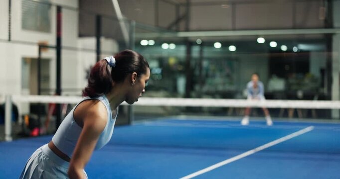 Sports, woman and playing padel on court for match practice, game challenge or serving ball. Night, people and back of tennis player at club for technique training, fitness performance and tournament
