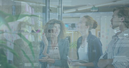 Brainstorming three professionals in office attire annotating glass in workspace with sticky notes