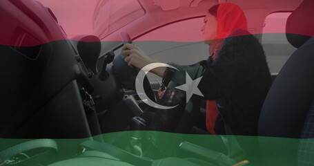 Gripping steering wheel woman wearing red hijab driving urban car cabin with seat belt, copy space