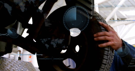 Mechanic in coveralls fitting tire onto wheel hub on diamond-plate lift, with digital overlays