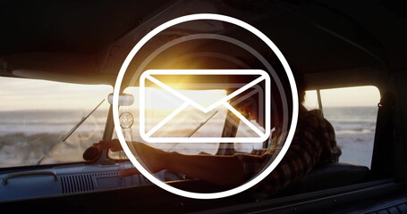 Man wearing flannel shirt reclining on camper dashboard at beach, dreamcatcher and envelope icon