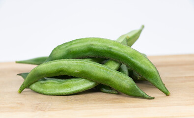 Close up of a wooden crate filled with broad beans,the green bean on background,