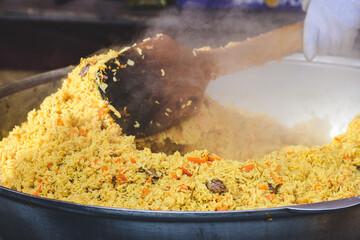 Preparing rice pilaf, a flavorful dish made with long-grain rice cooked in seasoned broth, lamb...
