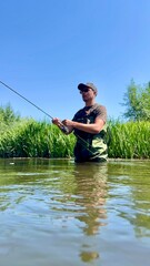 Man fishing in a river on a bright summer day