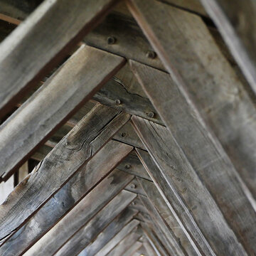 old weather wooden construction of a roof in a view from below