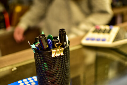 Close-up of the pen holder on the table in a shop. Pens in the pen holder.