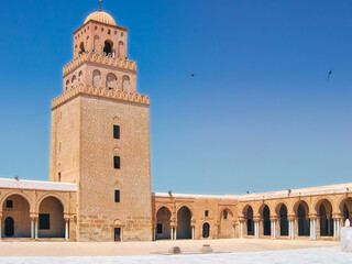 Fototapeta premium The minaret of the Great Mosque of Kairouan rises from sunlit silence — a fortress of faith built in stone, centuries before the first cathedral bell.