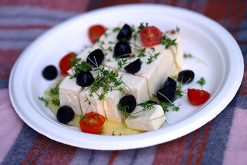 Feta cheese with olives, tomatoes and microgreens.