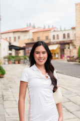 Fototapeta premium Asian woman walking wearing white polo shirt on European style city street summer fashion style