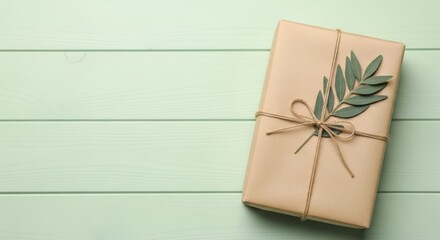 Elegant present wrapped in earthy tones adorned with botanical sprig on pastel surface creating