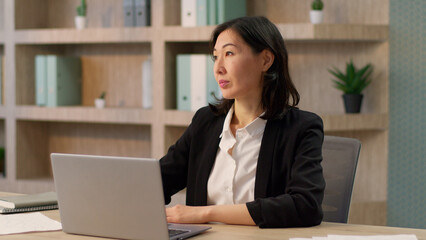 Thoughtful businesswoman Asian adult business person woman leader manager chinese korean girl japanese employer think contemplate female entrepreneur online work office smiling happy looking at camera