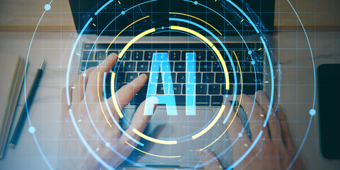 Hands typing on laptop keyboard with AI digital interface overlay showing futuristic artificial intelligence concept in technology workspace environment.