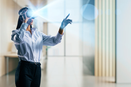 Businesswoman using immersive VR headset in modern office environment for digital interaction and corporate technology engagement concept.